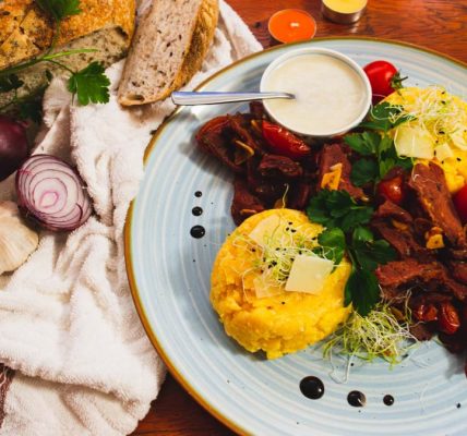 Delicious Romanian cuisine featuring polenta, vegetables, and artisan bread in a vibrant setting.